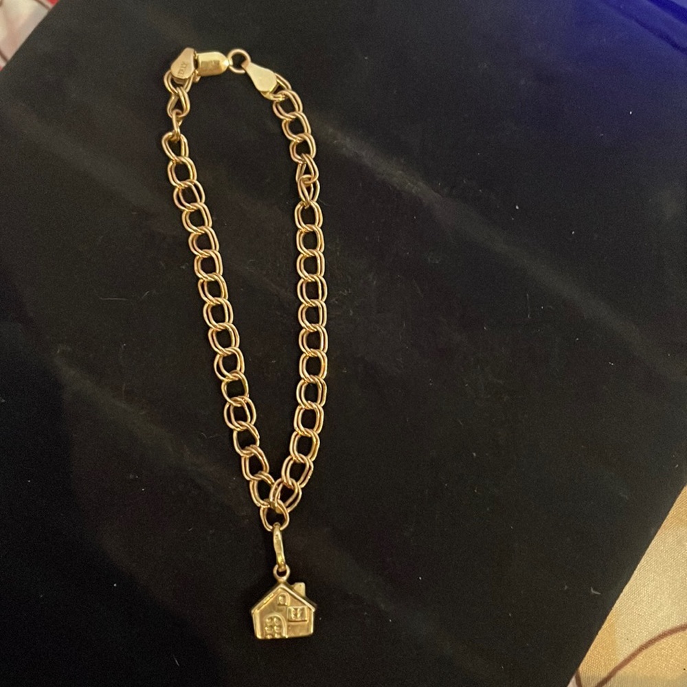 Cute 14k charm bracelet with house charm also 14k. Not plated.